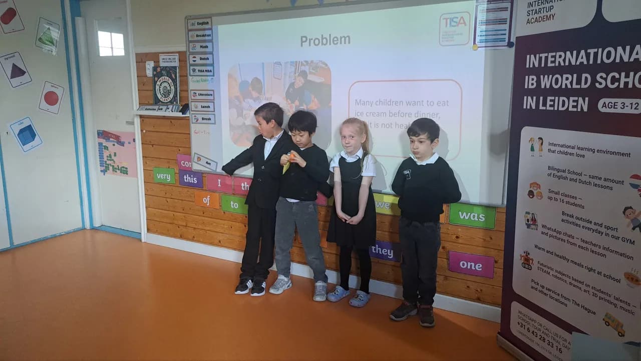 Four TISA Business students pitching their Problem slide under the TISA banner