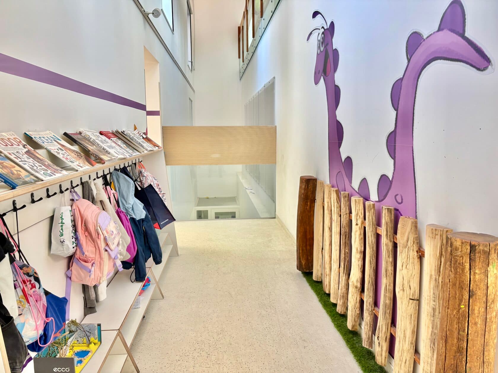 TISA Lisbon hallway with a purple dinosaur mural and children's coat racks